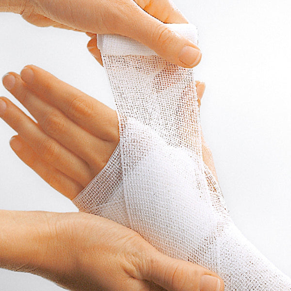 Hand applying white bandage to another hand on a light gray background